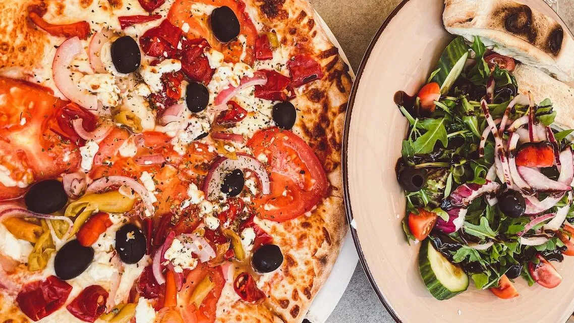 Pizza and salad on white plates